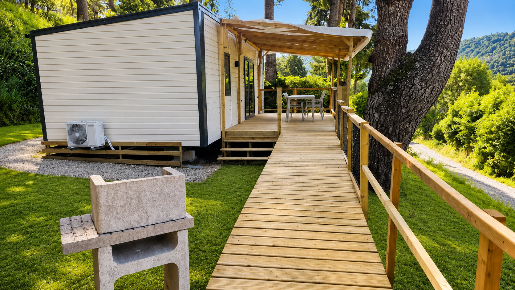 mobil-home climatisé PMR 4 personnes avec rampe d’accès en bois vers la terrasse